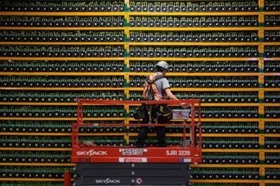 A picture of a well-maintained cryptocurrency mining farm with rows of ASICs.